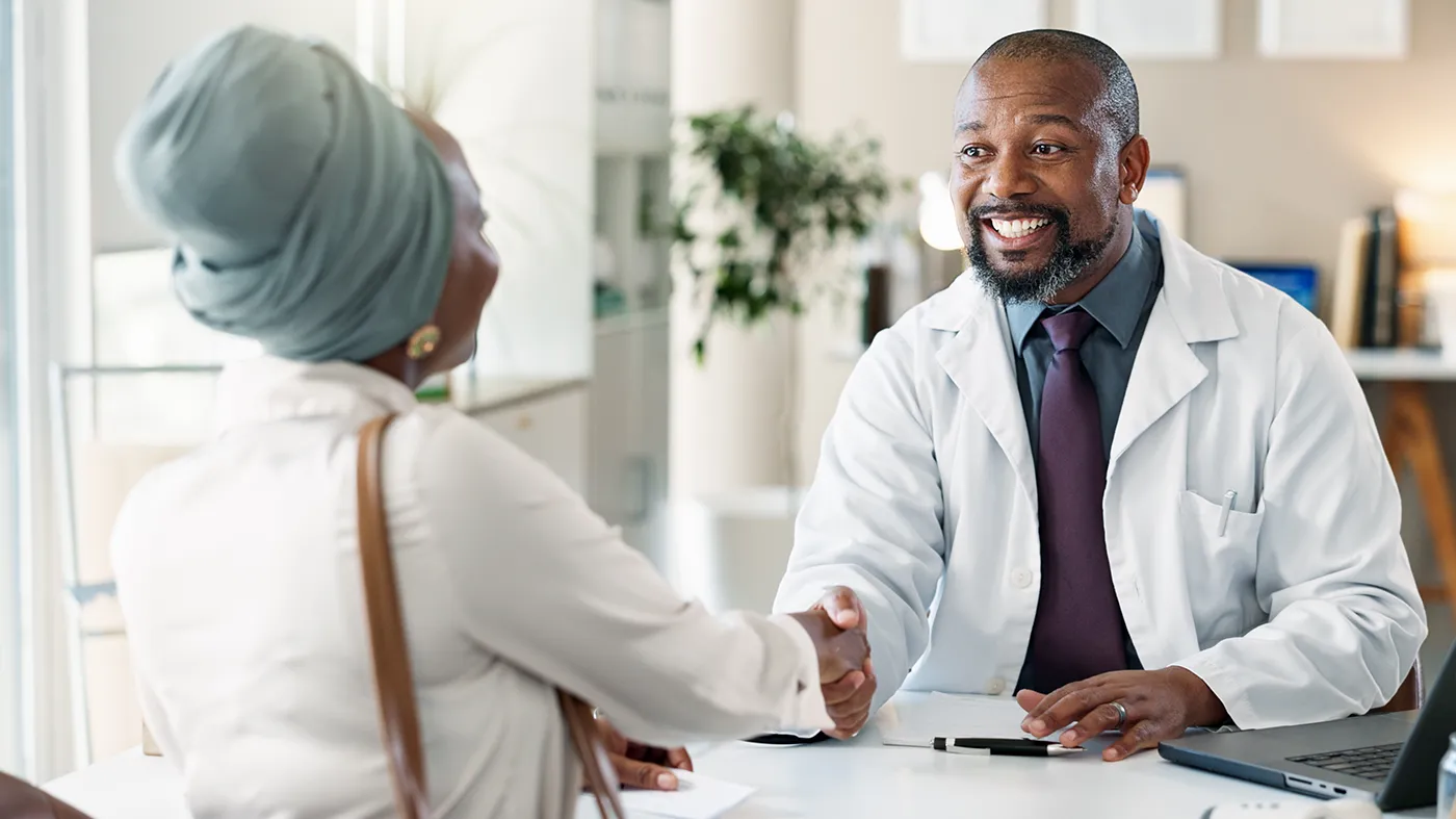 Doctor greeting patient with handshake in a welcoming setting, representing insomnia clinical trials with nationwide access at Equity Medical