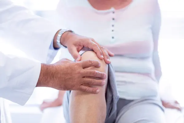 Doctor examining knee joint for osteoarthritis clinical trials at Equity Medical