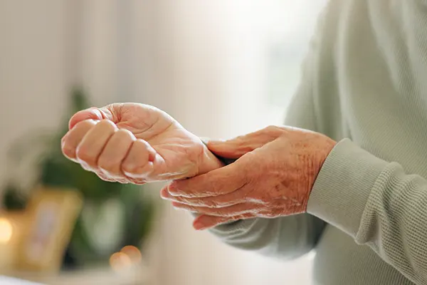 Doctor examining patient’s hand for psoriatic arthritis symptoms during a clinical trial evaluation at Equity Medical