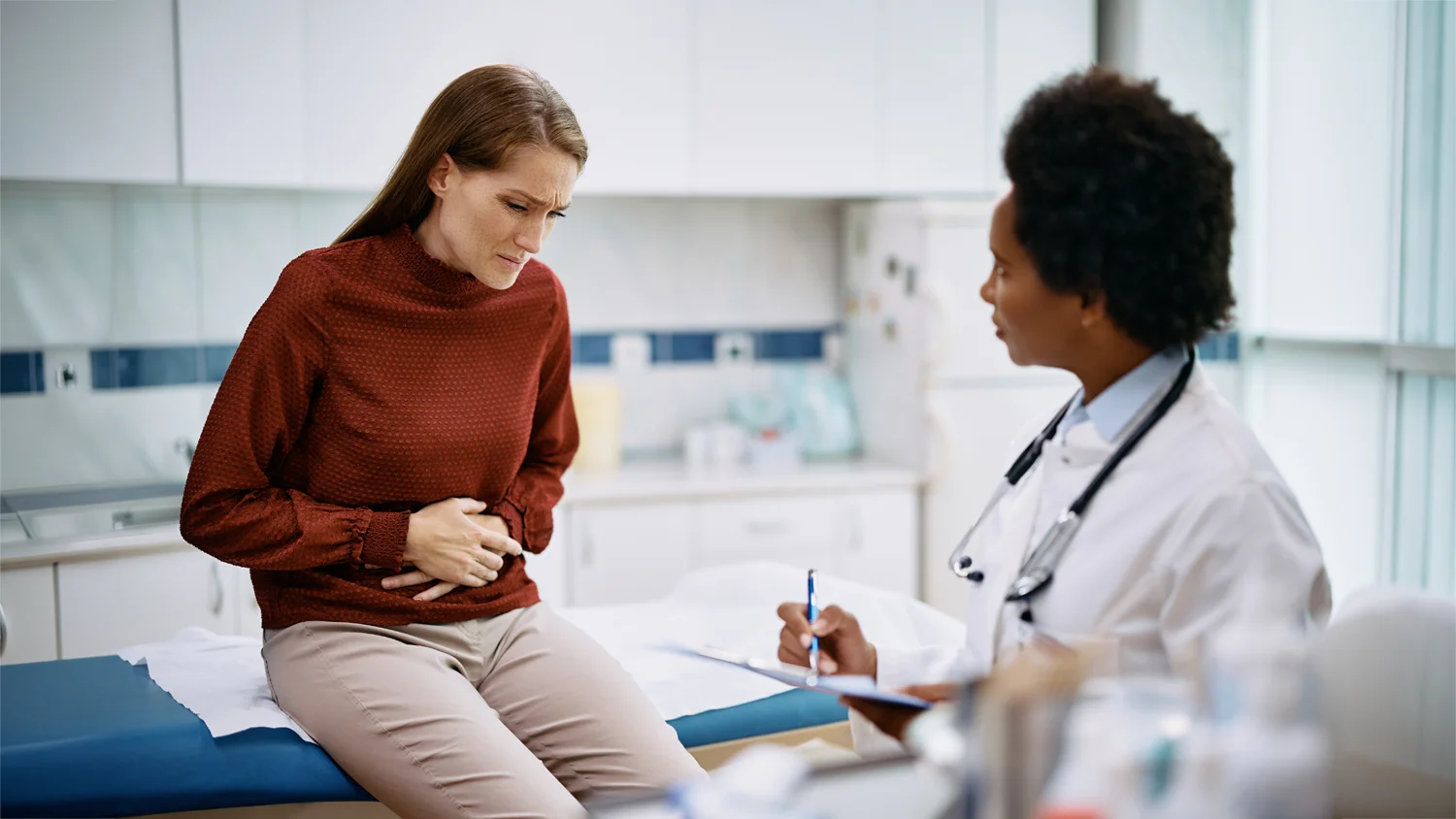 Woman experiencing pelvic pain associated with uterine fibroids before discussing clinical trial eligibility at Equity Medical.